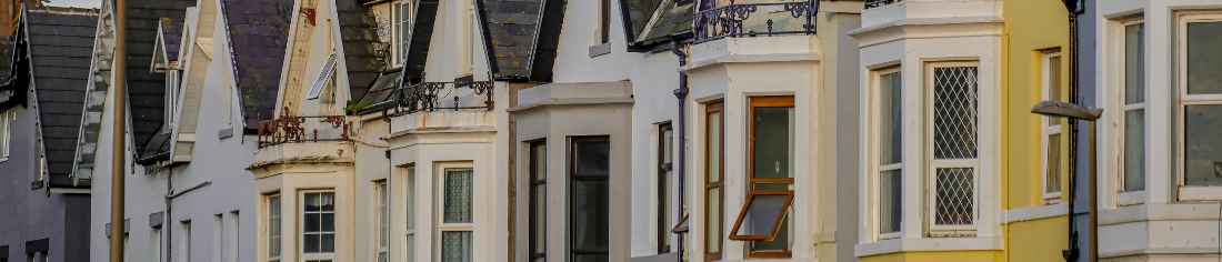 A stock image showing the first floor bay windows of a row of terraced housing in a UK street