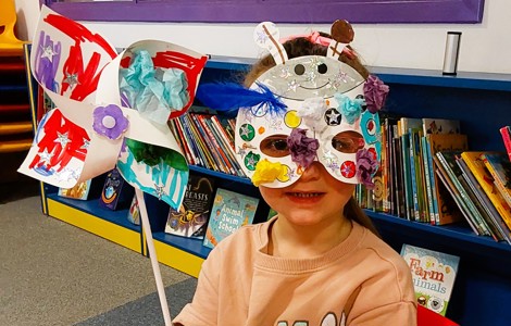 Child with painted windmill and mask