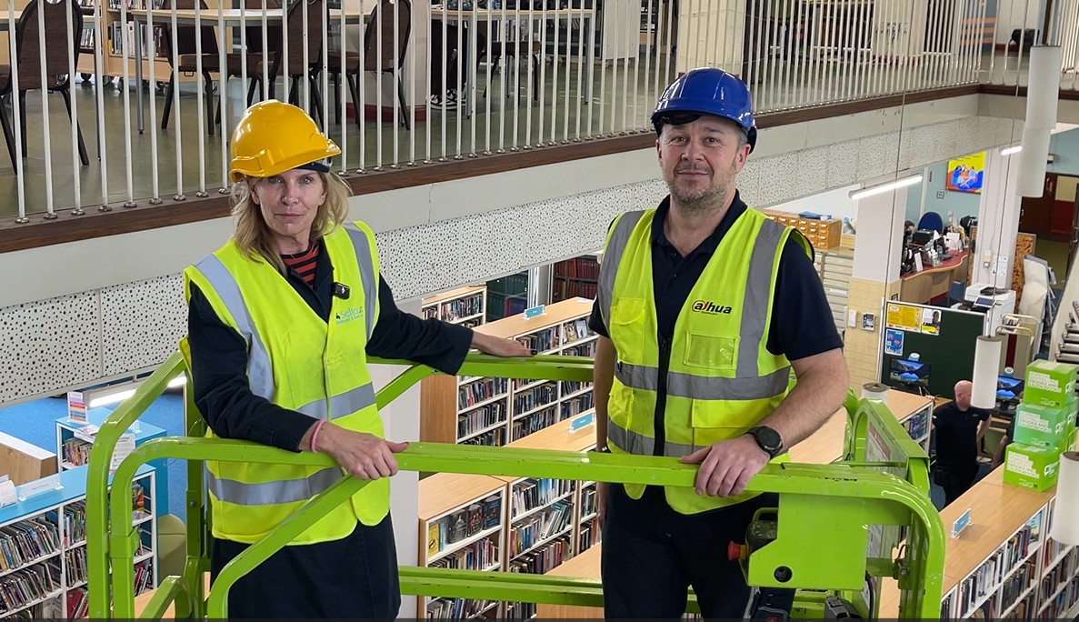 Cllr Liz Dowd and engineer from Sefton Arc on a scissor lift at Crosby Library